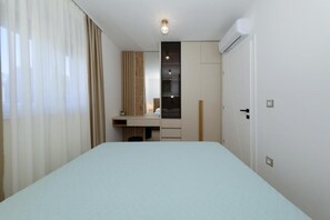 Ein Hotelzimmer mit Bett, Schreibtisch, Kleiderschrank und Klimaanlage.