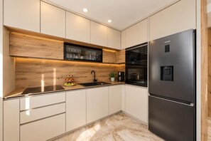 Sleek modern kitchen with light cabinetry, wooden accents, integrated appliances, and practical work surfaces. - Villa Casa Verde - Three Bedroom Villa, Sleeps 6 (Debeljak)