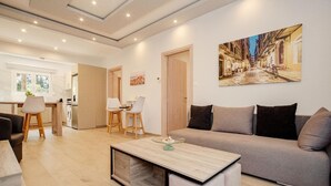 Ein modernes Wohnzimmer mit einer Couch, einem Couchtisch und einem Essbereich mit Stühlen.