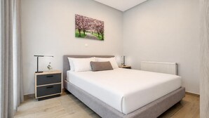Ein Schlafzimmer mit Bett, Nachttischen, einem Heizkörper und einem Wandbild.
