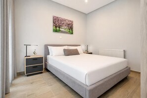 A bedroom with a bed, bedside tables, a radiator, and a wall-mounted picture. - Villa Boltado - Two Bedroom Villa, Sleeps 4 (Lefkimmi)