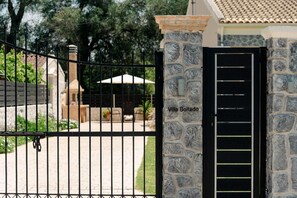 Ein verschlossener Eingang mit einer Steinpfeiler, der mit 'Villa Bolitado' beschriftet ist, und einem schwarzen Tor.