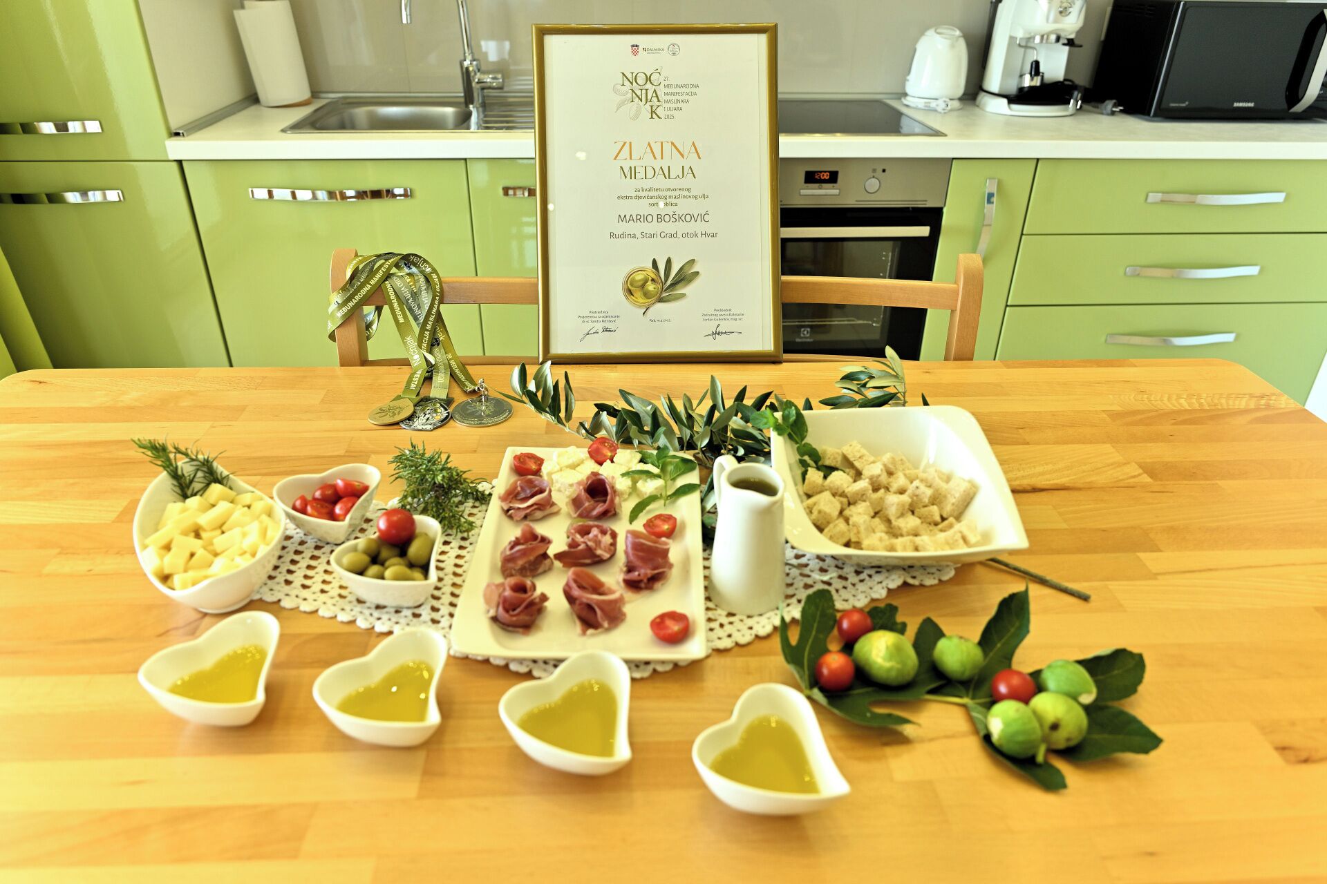 Een tafel met een inlijsting gezet certificaat, hartvormige schaaltjes olijfolie en diverse soorten eten.