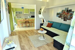 Ein modernes Wohnzimmer mit einer Couch, einem Couchtisch und einem Essbereich mit Tisch und Stühlen.
