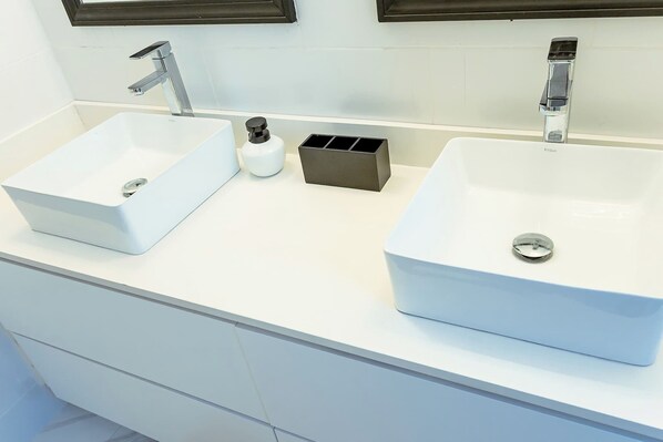 A bathroom with two white sinks, a soap dispenser, and a black soap dish. - Summer Escape-2br Apt-pool-7 Min Airport-pool (Montego Bay)