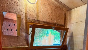 A wooden bathroom with a window, a sink, a toilet, and a small cabinet. - Lodge de l'Elle - Premium Lodge and Nordic Bath (Moon-sur-Elle)
