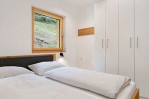 Une chambre à coucher avec un lit, une fenêtre et une armoire.