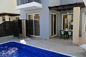 Ein Wohnhaus mit Schwimmbad, Balkon und Essbereich.