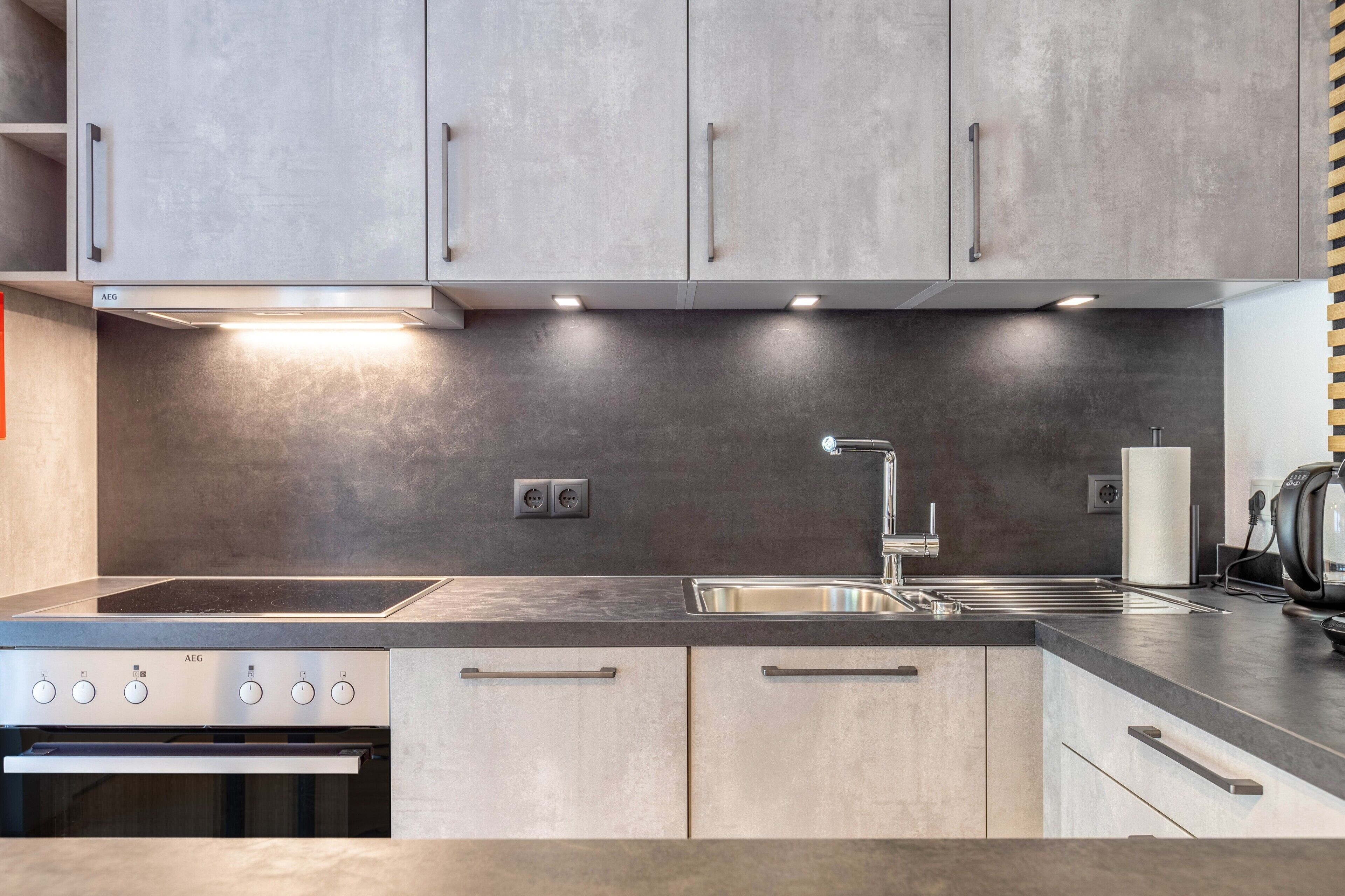 A modern kitchen with stainless steel appliances, a built-in oven, and a sink with a faucet.