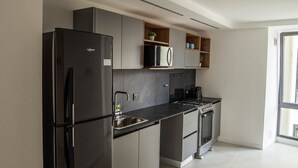 Eine moderne Küche mit einem schwarzen Kühlschrank, einem Herd und einem Spülbecken.