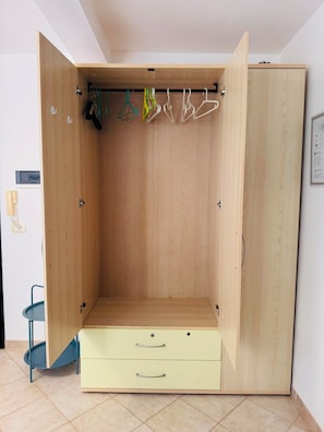 A wooden wardrobe with a hanging rod and two drawers. - Fully furnished studio apartment across from Angulo Beach (Santa Maria)