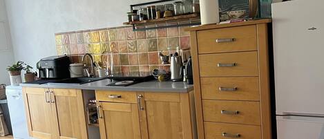 A kitchen with wooden cabinets, a countertop, and a tiled backsplash.