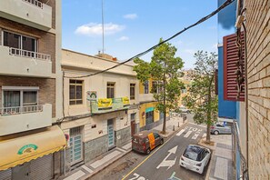 A narrow urban street with buildings on either side, a tree, and a parked car. - Vacation Apartment 'Matias Padron House' with Balcony and Wi-Fi (Las Palmas de Gran Canaria)
