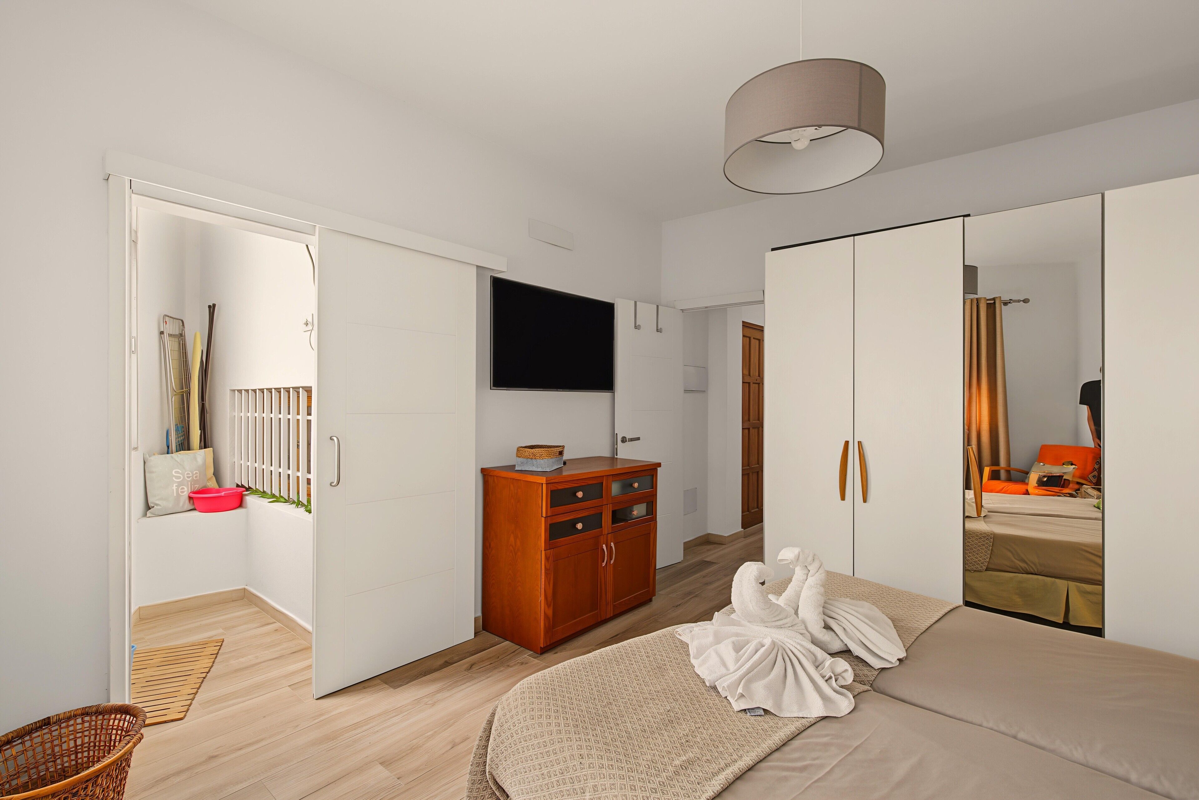 Ein Schlafzimmer mit einem Bett, einem Kleiderschrank, einem Fernseher und einem Spiegel.