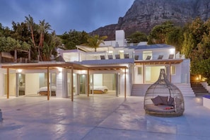 A modern house with a spacious outdoor area, a large bed, and a hanging chair. - Jacuzzi, Large Villa, 2 Pools, Camps Bay -Two Views (Cape Town)