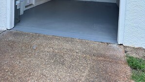 Eine Garage mit weißer Außenfassade, einer Tür und einer Deckenleuchte.
