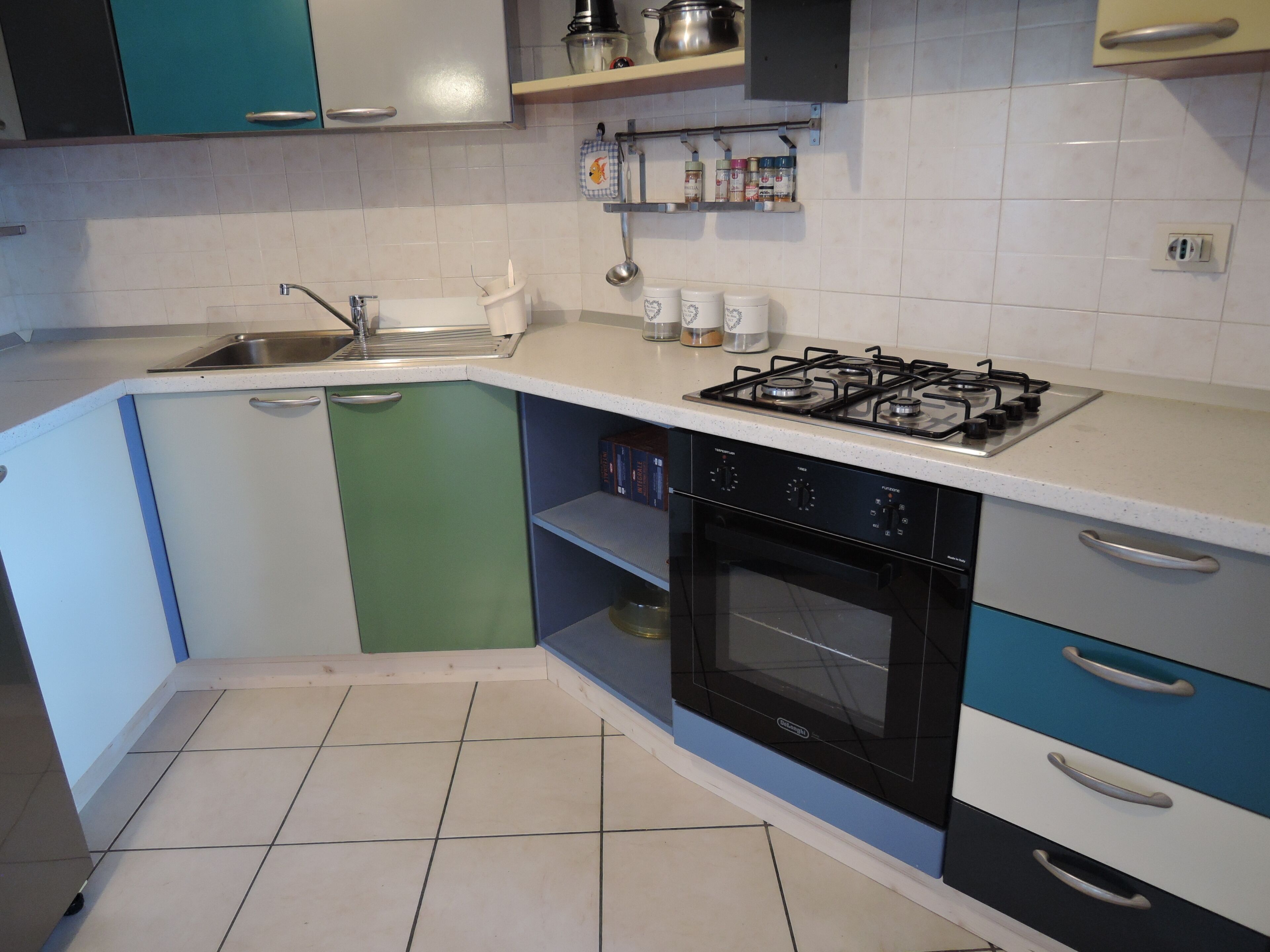A kitchen with a gas stove, sink, and cabinets.