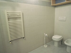 A bathroom with a white toilet, bidet, and a towel rack. - DOMUS ARTIS (Verona)