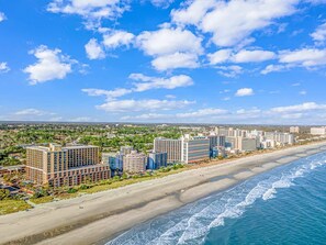 A coastal hotel area with multiple high-rise buildings, a sandy beach, and a view of the ocean. - Caravelle 624 Oceanfront Studio (Myrtle Beach)