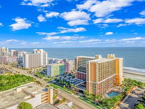 A coastal cityscape with high-rise buildings, a beachfront, and a clear blue sky. - Caravelle 624 Oceanfront Studio (Myrtle Beach)