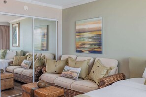 A living room with a sofa set, a large mirror, and a painting on the wall. - Caravelle 624 Oceanfront Studio (Myrtle Beach)