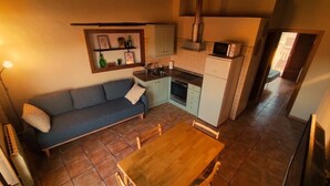 Une cuisine compacte avec un coin repas, un canapé et une petite table.