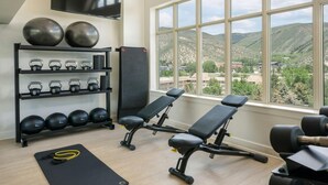 A gym with a bench press, kettlebells, and dumbbells. - Experience the Ultimate Family Getaway at Sheraton Mountain Vista's 2-Bd Lockoff (Avon)