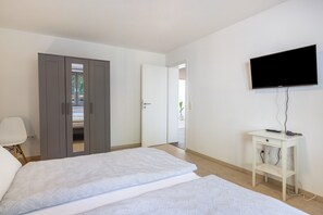 Una habitación de hotel con cama, televisión, escritorio y armario.