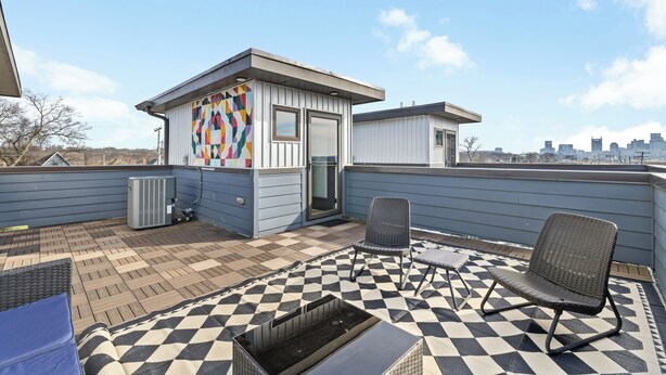 A rooftop patio with a checkered floor, a small building with a colorful wall, and a city skyline in the background. - NEW! 2 NashHomes! The Perfect Couple (Nashville)