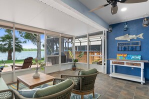 A covered patio with outdoor seating, a coffee bar, and a view of a lake. - WATERFRONT lakehouse with kayaks and dock, firepit and hot tub. (Crystal River)
