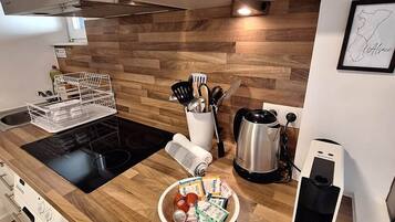 Une cuisine moderne dotée d’un plan de travail en bois, d’appareils électroménagers en acier inoxydable et d’une machine à café.