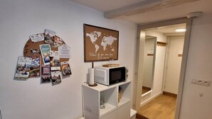 A room with a white cabinet, a world map, and a small TV on top. - To complete (Strasbourg)