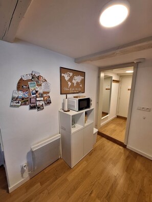 A room with a white cabinet, a world map, and a small TV on top. - To complete (Strasbourg)
