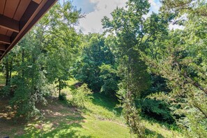Ein überdachter Außenbereich mit Blick auf einen dichten Wald.