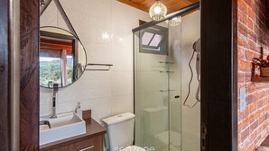 A modern bathroom with a glass shower enclosure, a white sink, and a wooden vanity. - House w/ Jacuzzi & Mountain View Rcn0000 (Urubici)