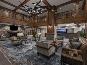 A spacious lobby with a high ceiling, stone fireplace, and a seating area with sofas and a coffee table. - Studio Villa Lake Tahoe Grand Residence Resort (South Lake Tahoe)