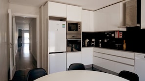 A modern kitchen with white cabinetry, a built-in oven, and a microwave. - Spacious 4-Bedroom Villa in Fernão Ferro with Private Terrace, Wi-Fi & Air Conditioning (Fernão Ferro)