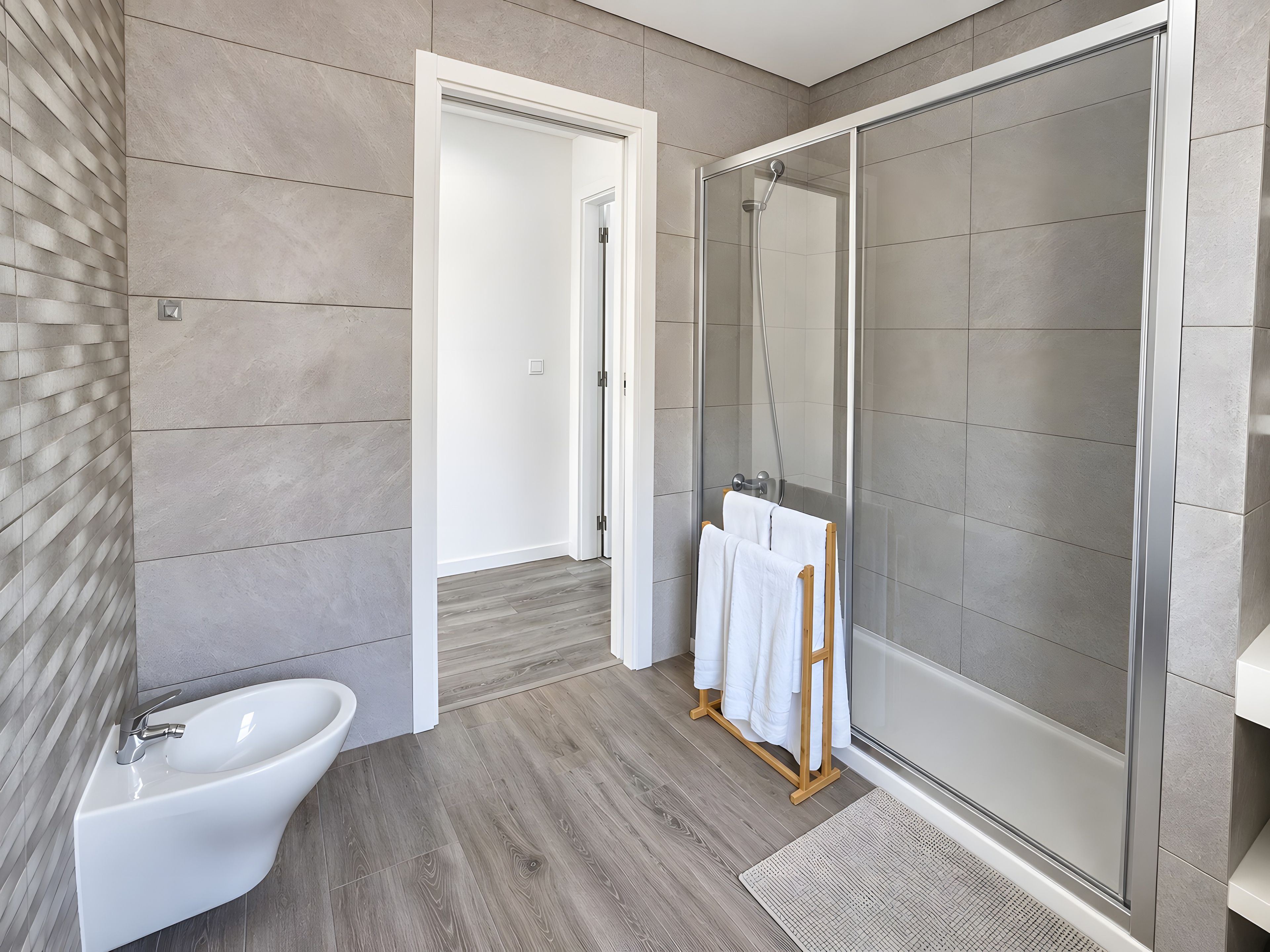 Ein modernes Badezimmer mit Dusche, Waschbecken und Handtuchhalter.