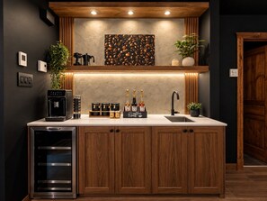 A modern kitchen with a built-in espresso machine, a coffee station, and a sink. - Tremblant Prestige - Les Eaux 217-5A (Mont-Tremblant)