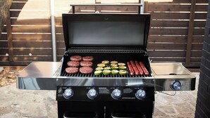 Ein Grill mit mehreren Kochzonen, einem digitalen Display und einer Edelstahl-Oberfläche.