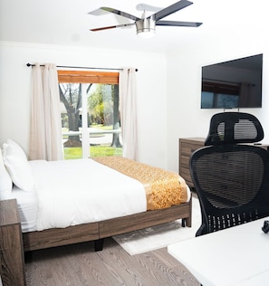 A bedroom with a bed, a desk, a chair, a TV, and a window with curtains. - Eden Luxury - 3 bedroom house in lovely Richardson, DFW Area (Richardson)