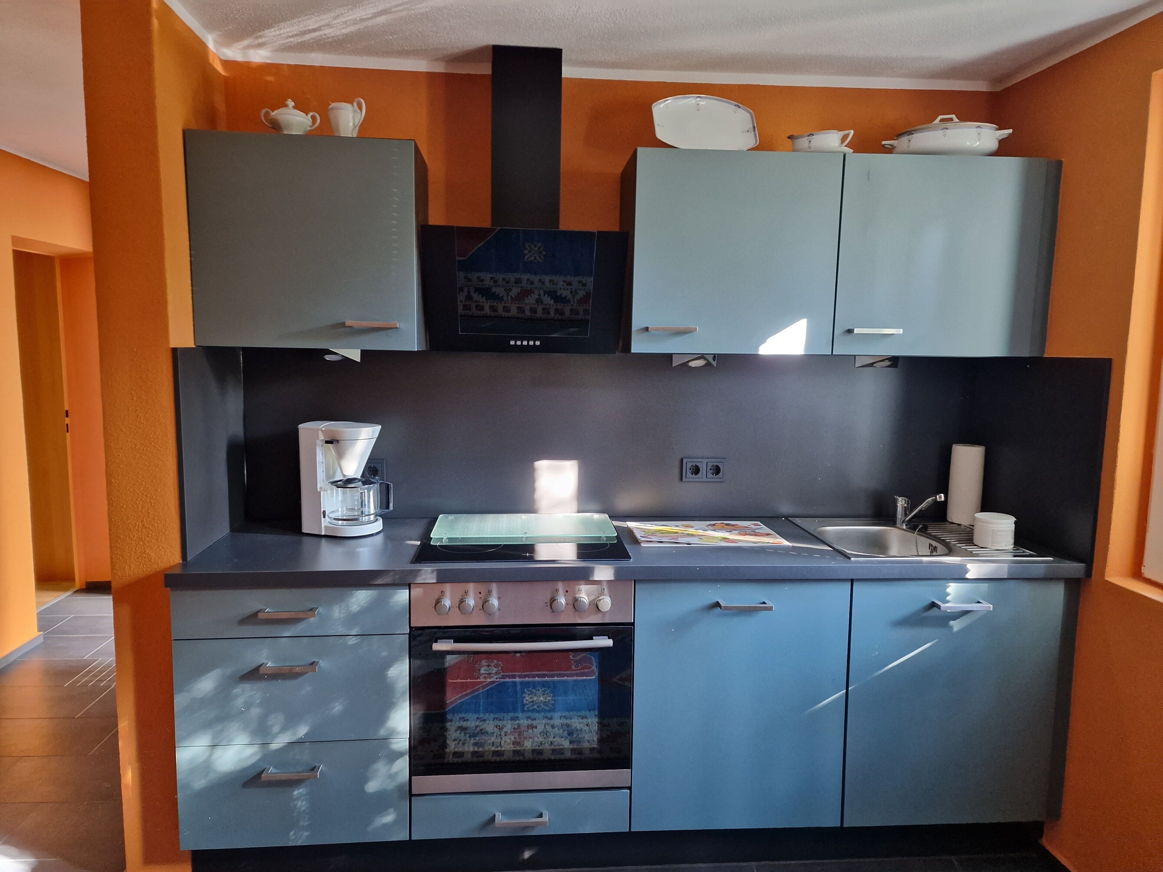Cafetera o tetera, frigorífico, horno y placa de cocina