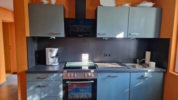 Cafetera o tetera, frigorífico, horno y placa de cocina