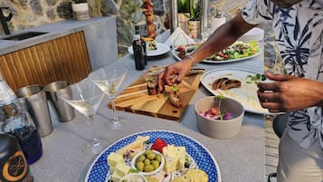 Un espace repas agrémenté d’un mur en pierre, d’un comptoir en bois et offrant un choix varié de plats et de boissons.
