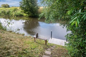 A riverside bench with a wooden dock extending into the water. - Holiday Home 'Silke' with Private Terrace, Garden & Wi-Fi near the North Sea for up to 4 Guests (Meldorf)