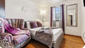 A bedroom with a bed, a chair, a ceiling fan, and wall-mounted butterfly decorations. - Family Safe NOLA-Area : MSY Airport : GAME ROOM : FREE Park'n : 3 BEDS (Destrehan)