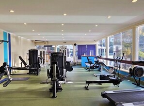 A gym with cardio machines, weightlifting equipment, and a blue wall. - 3-bedroom Villa with Private Pool & Panoramic views - Santo António Golf Resort (Faro District)