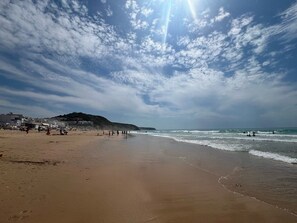 A beach with people, a clear sky, and buildings in the background. - 3-bedroom Villa with Private Pool & Panoramic views - Santo António Golf Resort (Faro District)