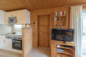 Eine kleine Küche mit Mikrowelle, Backofen und Holzschränken.