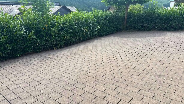 A paved outdoor area with a curved pathway, surrounded by dense greenery and a hedge. - Holiday Apartment in Westfeld near Winterberg with Terrace and Nature Views (Schmallenberg)